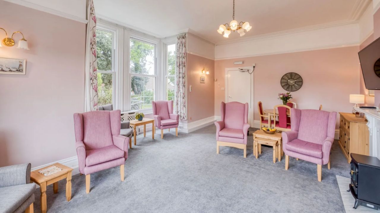 Interior of Romans care home, showing a light, bright lounge with several armchairs